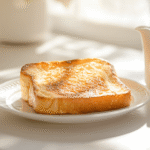 Slice of coffee creamer French toast on breakfast plate