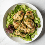 Instant Pot keto chicken pesto served on a modern white plate with salad on a marble counter