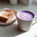 Purple ube latte served with breakfast on white counter