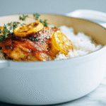 Cast iron skillet with one pot chicken and rice, topped with golden caramelized lemon slices