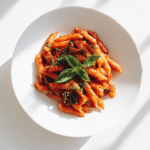 One pot pasta with spicy sauce and herbs on kitchen counter