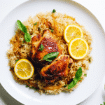 Crispy chicken skin with lemon rice on a modern white plate, close-up view