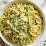 Creamy one pot protein pasta with chicken and pesto served in a white bowl